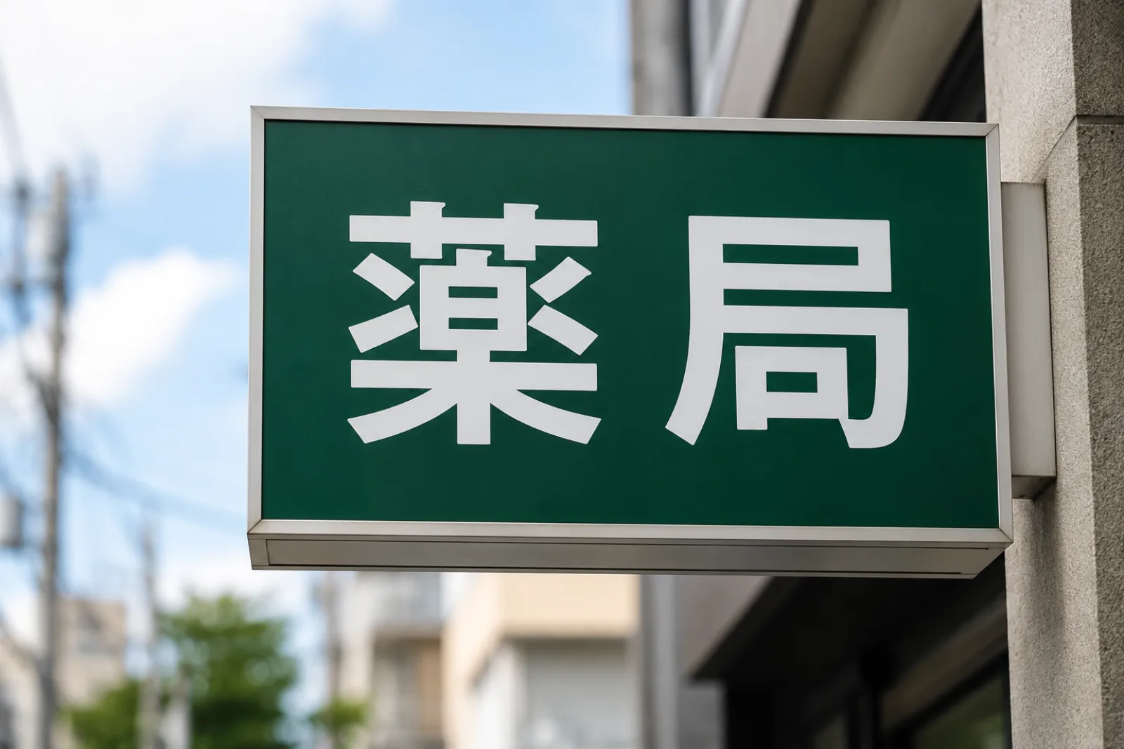 A green Japanese pharmacy sign displaying 薬局, the characters to look for on the street